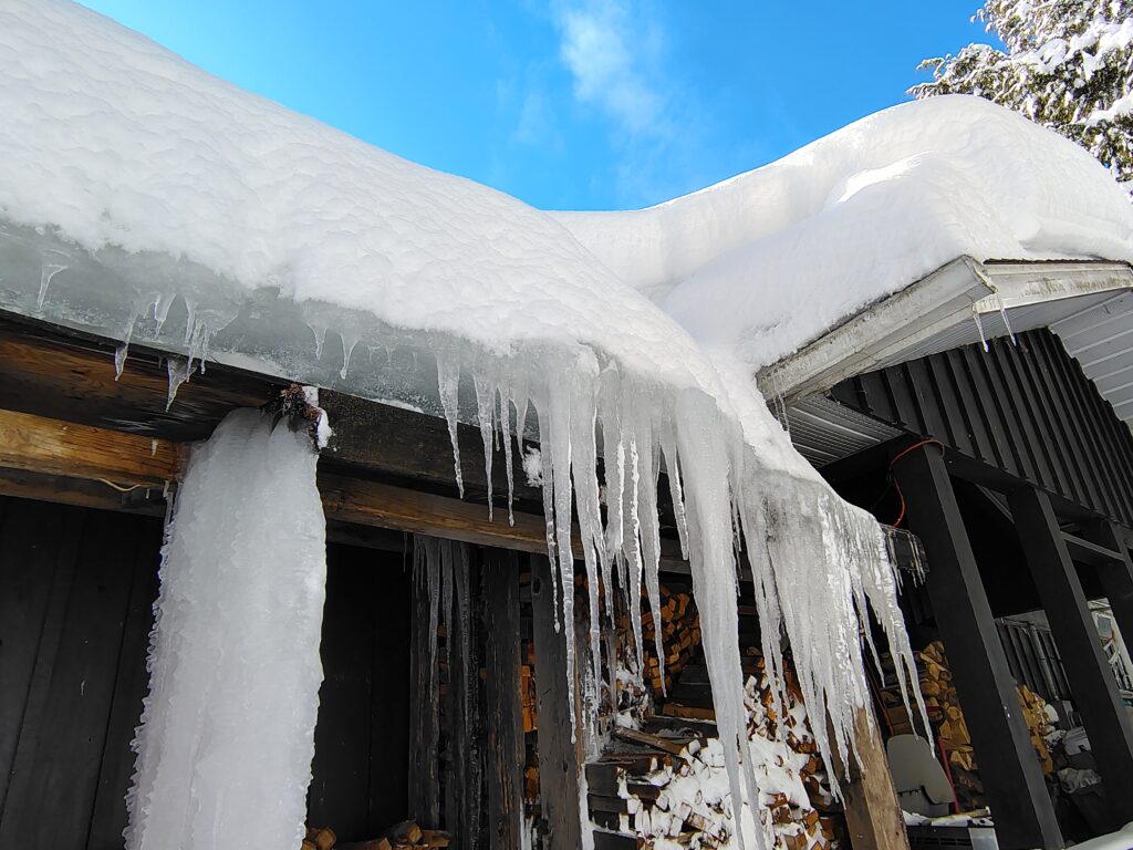 Winter ice and snow jam around roof eavestrough